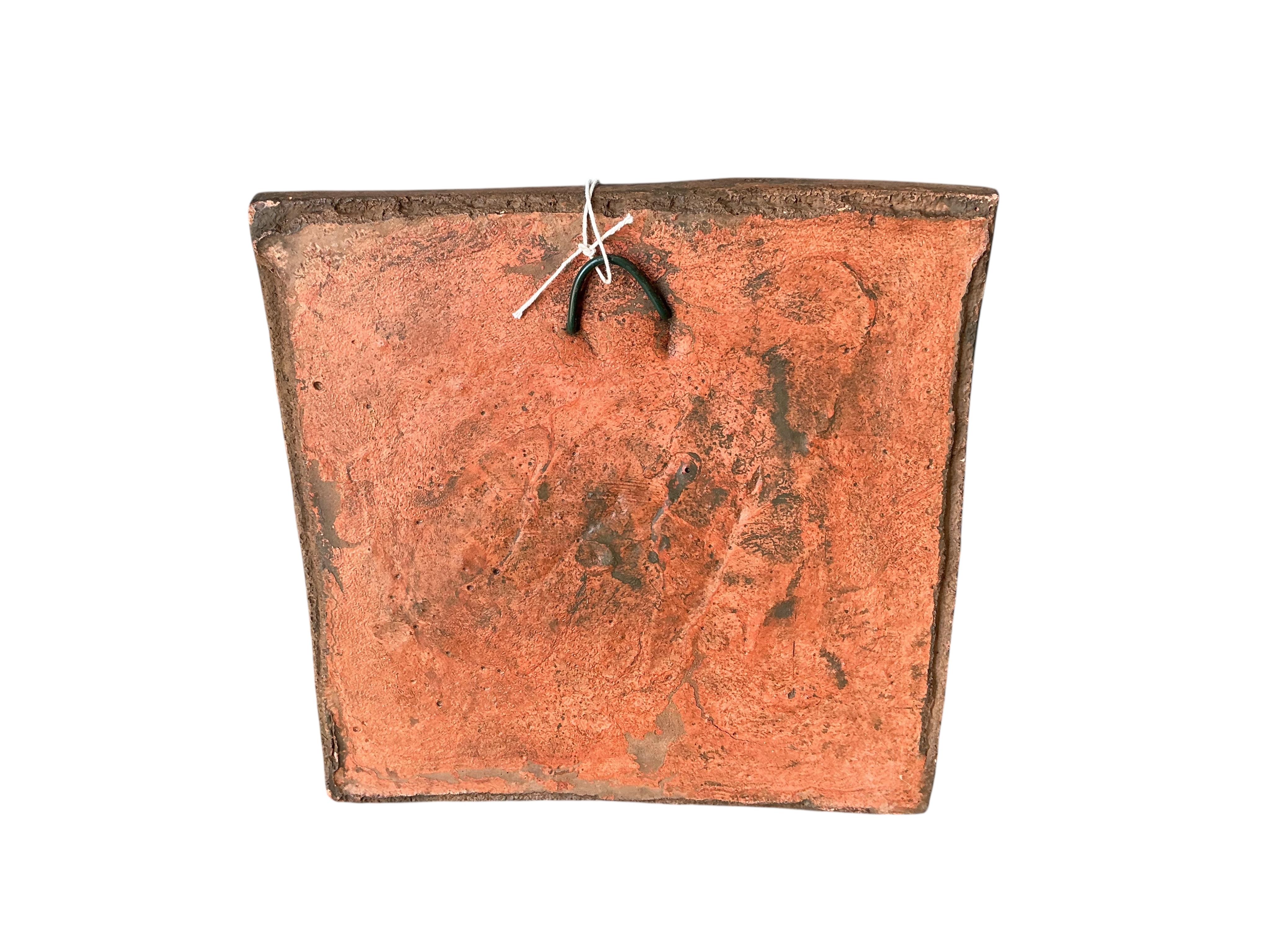 A terracotta lion mask garden wall tile, width 29cm, height 30cm
